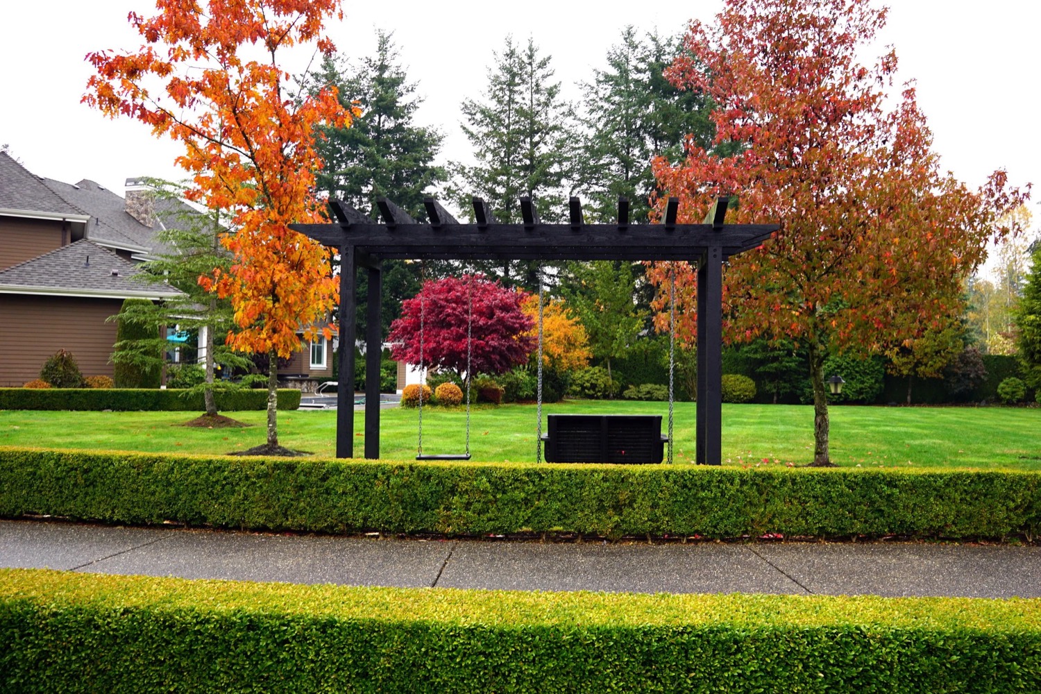 A maintained lawn, hedging and pergola